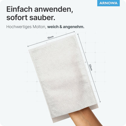 Eine Hand trägt einen weißen ARNOMED Einmalwaschhandschuh aus Molton (75g/m², 15x22 cm) der ARNOWA GmbH, dargestellt vor einem hellen Hintergrund. Oben rechts sind der deutsche Text, das Dermatest-Siegel und das blaue ARNOVA-Logo zu sehen. Packung: 50 Stück.