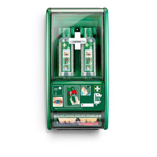 Eine grüne Cederroth Augenspülstation von Orkla Wound Care AB ist an der Wand montiert und enthält 2 x 500 ml Flaschen (725200) sowie einen Salvequick Pflasterspender (490700) mit bebilderten Notfallanweisungen und Symbolen.