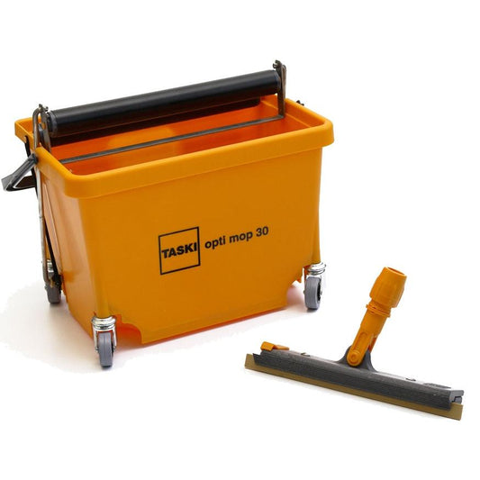 Ein TASKI Opti Mop 30 von Diversey (30 cm, 8 l Eimer, inkl. Presse und Wischkörper), ideal für Nassreinigen kleiner/überstellter Flächen, steht neben einem orange-grauen Bodenschaber.
