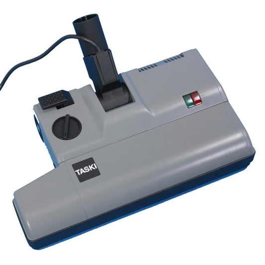 Die TASKI Elektrosaugbuerste 230V 38mm von Diversey Deutschland GmbH & Co. OHG ist ein grauer Saugkopf mit schwarzer Düse, runder Skala, Kabel und zwei Kontrollleuchten (rot/grün) auf der Oberseite. Verpackung: 1 Stück. Stromversorgung: 230V.
