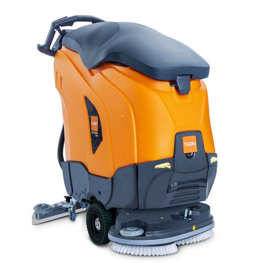 Die TASKI ULTIMAXX 1900 DD65 Performance BMS 40A EBU von Diversey verfügt über ein orange-graues Gehäuse, sichtbare Schrubbbürsten, Räder und einen Griff. Mit Radantrieb für effiziente Bewegung, verfügt sie über einen 43L Tank und 65cm Doppelscheibe.