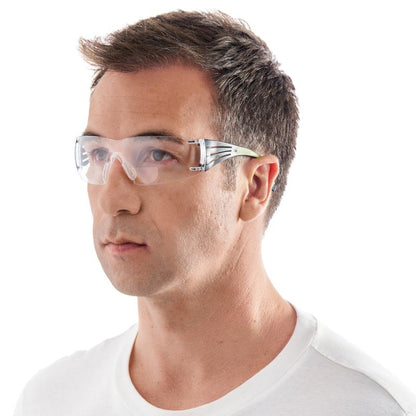 A man with short brown hair is wearing a 3M™ SecureFit™ reading safety glasses from 3M Deutschland GmbH and a white crew-neck T-shirt, slightly turned to the left against a plain white background.