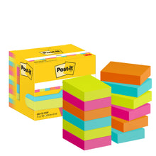 Eine gelbe Schachtel Post-it® Notes (3M Deutschland GmbH, Poptimistic Collection, 38 x 51 mm, 100 Blatt/Block, 12 Blöcke/Packung) steht neben Stapeln von quadratischen Haftnotizen in leuchtendem Gelb, Pink, Blau, Orange und Grün.
