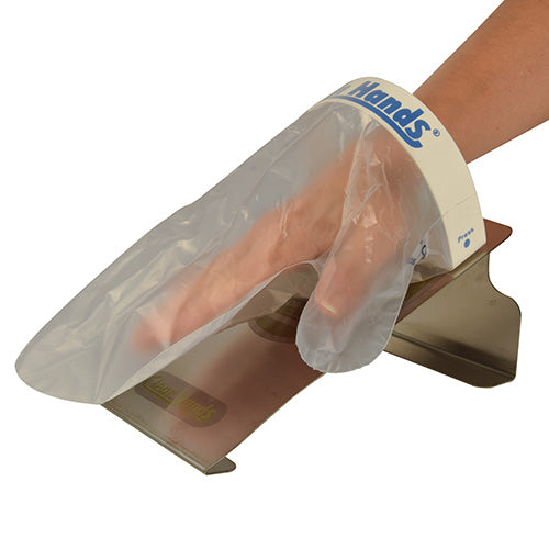 Eine Hand mit einem Einmalhandschuh aus dem PAPSTAR Clean Hands Base Kit Edelstahl (11,5 x 12,7 x 22 cm, silber | Faltschachtel) der PAPSTAR GmbH liegt über einer Edelstahlfläche und scheint am Hygienespender „Handi Hands“ befestigt zu sein.