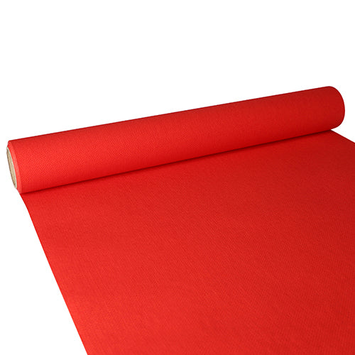 Ein teilweise ausgerollter PAPSTAR Tischläufer, Tissue „ROYAL Collection“ (3 m x 40 cm) der PAPSTAR GmbH zeigt seine strukturierte rote Oberfläche und den zylindrischen Kartonkern, wenn er sich über eine ebene Fläche erstreckt.