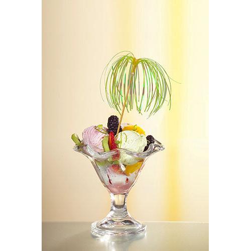 A glass dessert bowl with ice cream, various fruits, and berries is garnished with a decoration pick PAPSTAR 100 from PAPSTAR GmbH and stands in front of a gently yellow-lit background - perfect for stylish presentations.