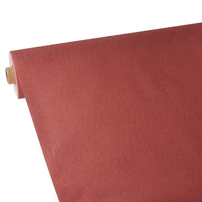 A roll of Starpak tablecloth, fabric-like, fleece "soft selection plus" is partially unrolled on a flat surface, revealing the reddish-brown color and the exposed cardboard core at one end.