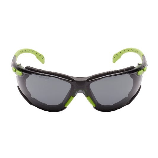 Die 3M™ Solus™ Schutzbrille 1000 von 3M Deutschland GmbH zeichnet sich durch graues Glas, grünes/schwarzes Design, Scotchgard™ Antibeschlag-Beschichtung und aufsteckbare Schaumstoffdichtung aus; abgebildet vor weißem Hintergrund.