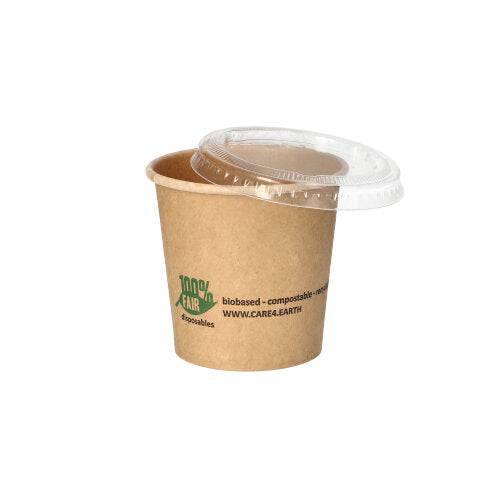Ein PAPSTAR 50 Portionsbecher aus brauner Pappe von PAPSTAR GmbH mit grünem Logo und Text liegt diagonal, klarer Kunststoffdeckel oben. Ideal als umweltfreundlicher Portionsbecher vor weißem Hintergrund.