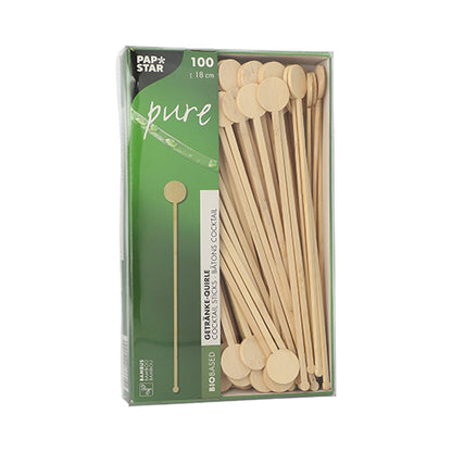 Eine Schachtel mit 100 PAPSTAR GmbH „pure“ Bambus-Getränke-Quirle, biologisch abbaubar, mit runden flachen Enden, teilweise sichtbar durch ein Sichtfenster in grüner und weißer PAPSTAR Pure Verpackung.