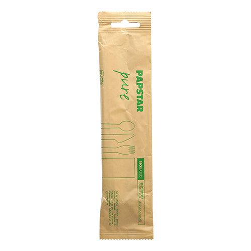 Eine versiegelte braune Papierpackung der PAPSTAR GmbH mit der Aufschrift „Besteckset, Holz pure“ enthält Messer, Gabel, Löffel und Serviette aus Holz; auf der Vorderseite sind grüner Text und Umrisse des Bestecks zu sehen.