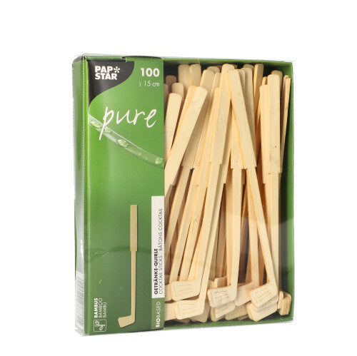 Eine grüne Box mit der Aufschrift „PAPSTAR 100 Getränke-Quirle, Bambus ‚pure‘“ der PAPSTAR GmbH enthält 100 umweltfreundliche Bambusrührstäbchen (ca. 15 cm), die teilweise durch ein Sichtfenster sichtbar sind. Die Box ist mit weißem Text und einer Blattgrafik versehen.