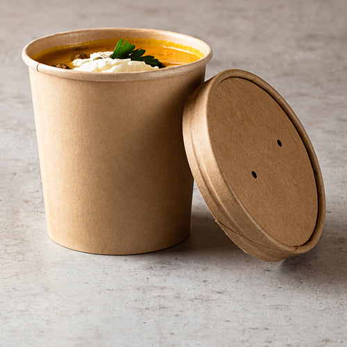 Auf einer hellen Arbeitsplatte steht ein brauner Starpak Suppenbecher, gefüllt mit Suppe, Sahne und Petersilie; Daneben ruht der Starpak 25 Deckel für Suppenbecher, Pappe rund.