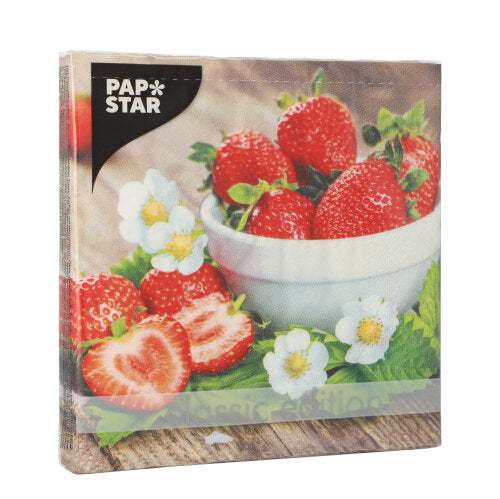 Ein Stapel PAPSTAR 20 Servietten, 33x33cm, 3-lagig von PAPSTAR GmbH, Set 2: Frische Erdbeeren - ganz und in Scheiben geschnitten - mit Blüten und grünen Blättern um eine weiße Schale auf einer Holzfläche.