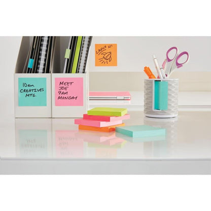 A tidy desk with 3M Deutschland GmbH Post-it® sticky notes (76 mm x 127 mm, 100 sheets/block, 100% PEFC), colorful pens and scissors in a holder, labeled folders, and pastel-colored sticky notes neatly stacked on a white surface.