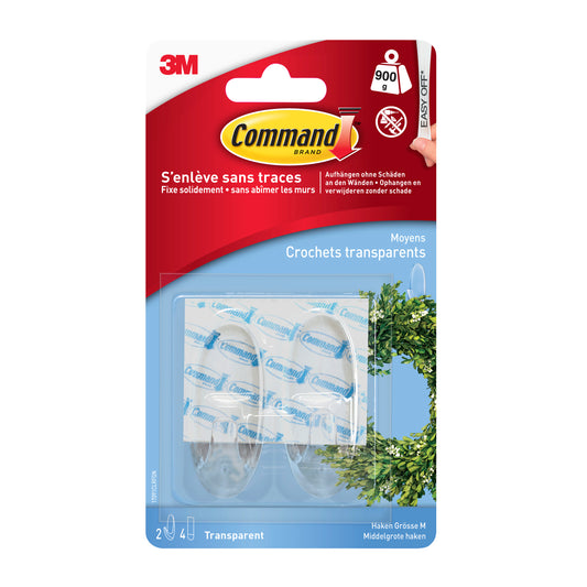 Eine Packung Command™ Haken M, mittel, transparent mit transparenten Streifen von 3M Deutschland GmbH (17091CLR). Die Verpackung ist überwiegend blau mit rot und weiß, mit französischem und deutschem Text. Zwei Haken und vier Streifen sind sichtbar.