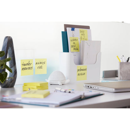 Ein aufgeräumter Schreibtisch mit Ordnern, 3M Deutschland GmbH Post-it® Super Sticky Notes (Gelb, 76x127mm, 90 Blatt/Block, 14+2 Promo-Pack), einem Laptop, Stiften, einer Pflanze, einer weißen Schildkröten-Deko und einem Notizbuch. Auf den Notizen steht: "Ressourcen übertragen", "Risiko minimieren", "Leistungsbeurteilung".