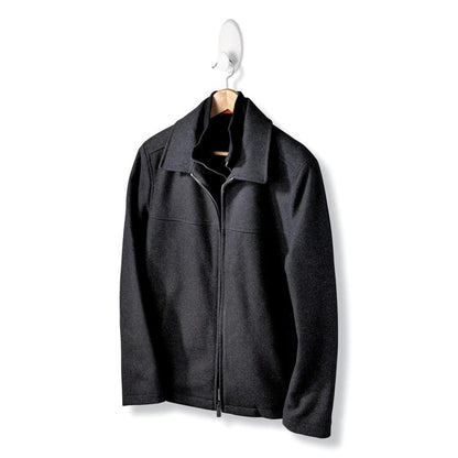 A black jacket with a zipper and collar hangs on a wooden hanger of the Command™ Clothes Hook, 17019-FGN, which allows wall mounting without drilling, against a simple white background.