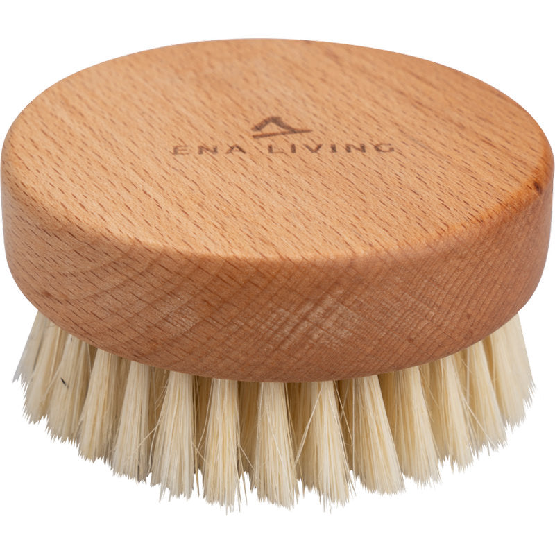 Die ENA Living Handmassage-Bürste von Abena Re-Seller GmbH ist eine runde Massagebürste aus Holz mit Naturborsten und der Gravur "ENA LIVING" auf der Oberseite. Verkauft im Karton mit 24 Packungen, ist es ideal für Entspannung und gegen einen weißen Hintergrund gezeigt.