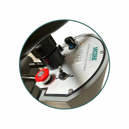 Close-up of the control panel of the Arcora Ro-Man 660Br/90L ride-on scrubber dryer from Arcora International GmbH with switches, indicator lights, and an emergency stop button on a metal surface.