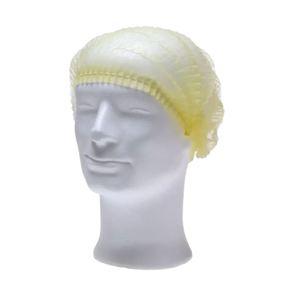 A white mannequin head presents an AMPri ECO-PLUS clip cap in light yellow, manufactured by AMPri Handelsgesellschaft mbH. The net, designed for the medical field, covers the top and sides and highlights its texture and fit against a white background.