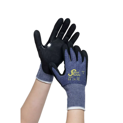 Two hands wear AMPri SolidSafety Cut protective gloves in black and blue with safety and size markings. These gloves offer exceptional grip with a textured surface on the palms and fingertips, making them ideal for maximum workplace safety.
