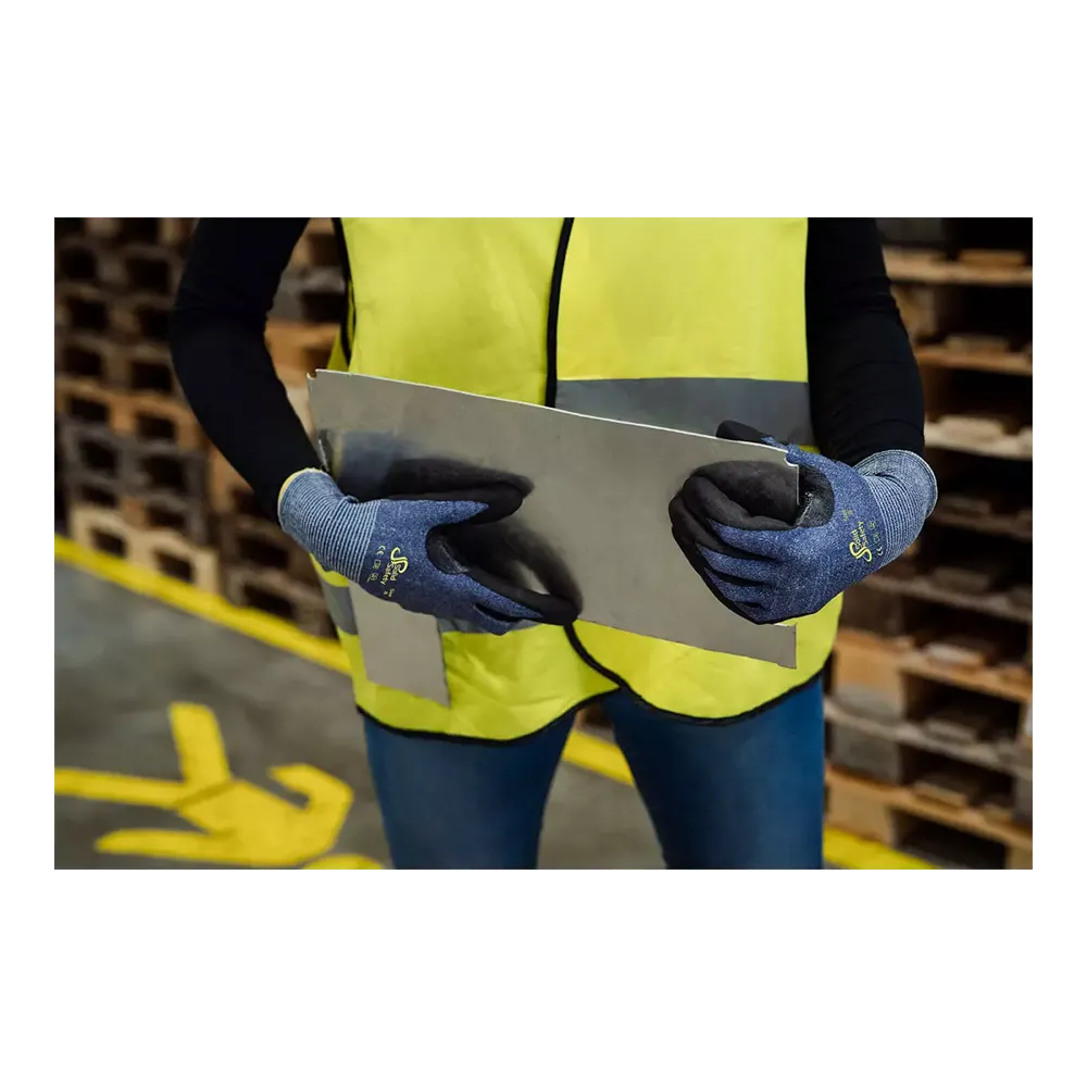 A person with a neon yellow safety vest and blue AMPri SolidSafety Cut cut-resistant gloves S - XXL from AMPri Handelsgesellschaft mbH carefully handles a large metal sheet in the warehouse. In the background, wooden pallets are stacked, yellow markings on the floor guide safe movements and emphasize occupational safety.