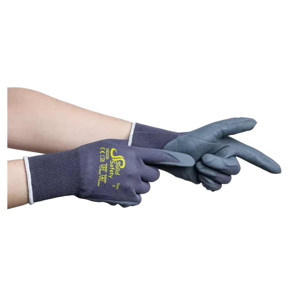 A pair of hands wearing dark gray AMPri SolidSafety Tough Micro Touch ultra-light assembly gloves, with yellow text and logos on the back of the hand. The gloves have a fabric cuff and a nitrile microfoam texture on the palm and fingers. One hand is pointing while the other adjusts the glove.