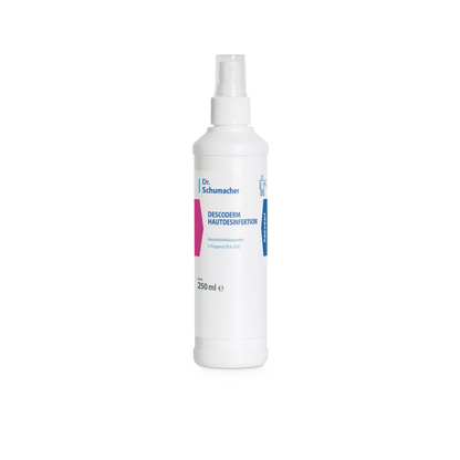 White 250 ml bottle of Dr. Schumacher GmbH Descoderm skin disinfection with spray head. The front label shows the product name and information about the disinfectant in blue and pink lettering.