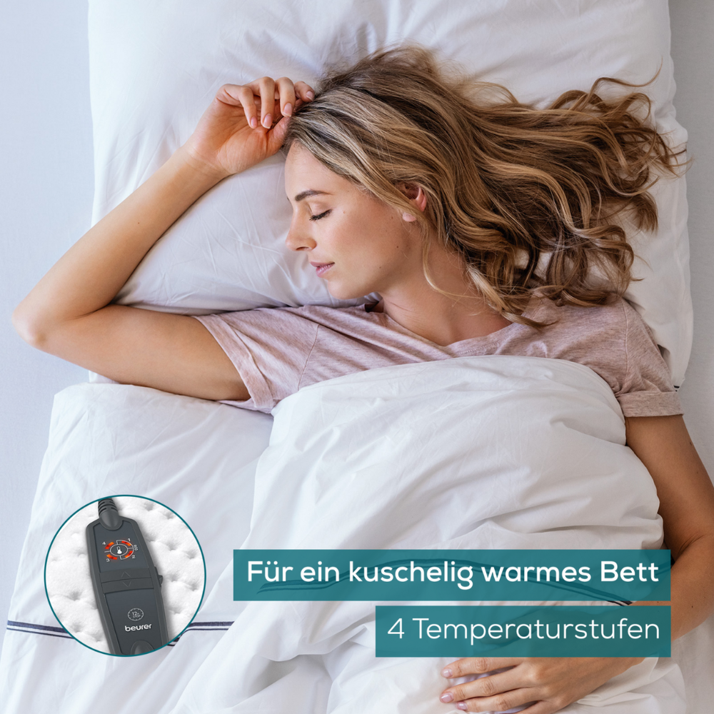 Eine Frau mit blondem Haar schläft in einem Bett mit weißer Bettwäsche. In einem Einschub ist ein dunkelfarbiges elektronisches Gerät mit Tasten zu sehen, wahrscheinlich eine Beurer Wärmeunterbett UB 60 Green Planet-Steuerung für eine Heizdecke der Beurer GmbH. Der deutsche Text lautet: „Für ein kuschelig warmes Bett“ und „4 Temperaturstufen.