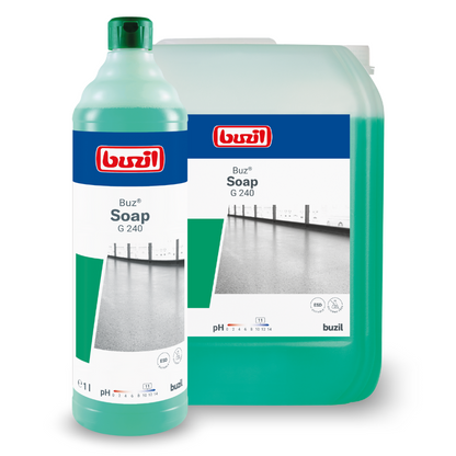 Two containers with cleaning agents are shown. In the foreground is a tall bottle with a green liquid labeled "Buzil Buz® Soap G 240 Wiping Care on a Soap Basis, ideal for floor cleaning, by BUZIL-WERK Wagner GmbH & Co. KG". In the background, a larger rectangular container with the same label can be seen. Both containers proudly display the red-blue logo.