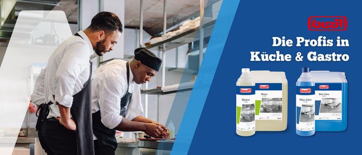 Zwei Köche arbeiten in einer Großküche beim Anrichten von Speisen zusammen. Rechts sind drei Flaschen mit Reinigungsmitteln mit dem Text "Die Profis in Küche & Gastro" und dem Buzil-Logo auf blauem Hintergrund abgebildet.
