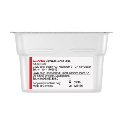 A white 80 ml container labeled "CWS ParadiseLine Washroom Fragrance for Fragrance Dispenser Paradise Air Bar" by CWS. Contains product information, manufacturer contacts in Switzerland and Germany, expiration date 05/19, batch 123456. For professional use only.