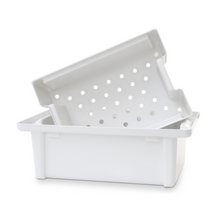 The Dr. Schumacher instrument tray from Dr. Schumacher GmbH is a white plastic tray with a matching, angled sieve insert with circular holes, perfect for disinfecting medical instruments.