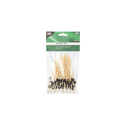 On a white background, a pack of 40 PAPSTAR finger food picks can be seen, each 12 cm large and equipped with black loops. The packaging was designed by PAPSTAR GmbH and features a green label at the top, emphasizing its role as a sustainable disposable product for finger food skewers.