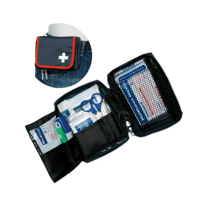 The Holthaus Medical first aid kit TRAVEL blue/red from Holthaus Medical GmbH & Co. KG is shown open and filled with medical supplies such as bandages, scissors, and antiseptic wipes. The cover is equipped with a white cross symbol and a belt attachment. An inserted image shows the set attached to a jeans belt.
