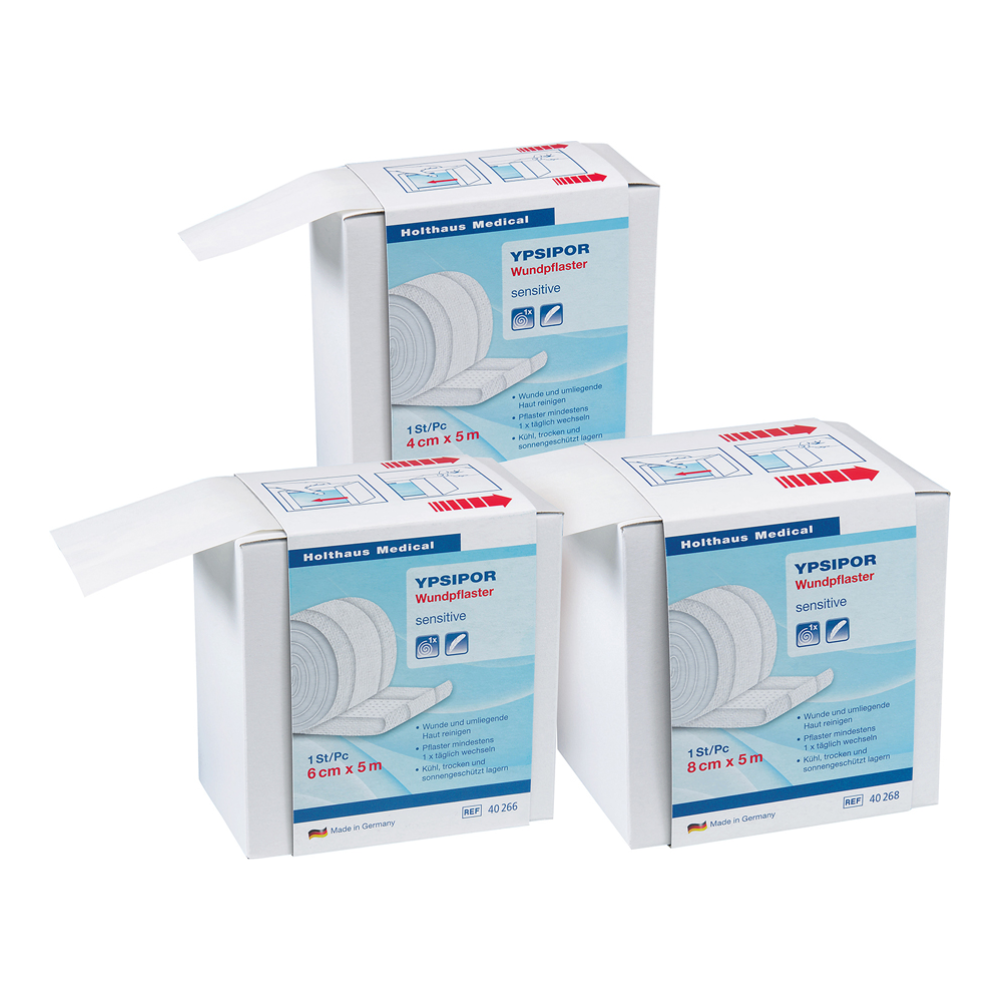 Three boxes of Holthaus Ypsipor wound plasters, fleece plasters by Holthaus Medical GmbH & Co. KG are depicted on a white background. Each box contains 18 pieces of skin-friendly fleece plaster measuring 6 cm x 5 m. The predominantly white packaging features blue and red accents and is perfect for first-aid items.