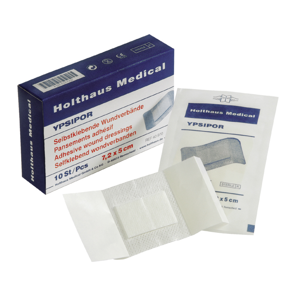 Eine geöffnete Schachtel Holthaus Ypsipor Wundverband, sterile selbstklebende Wundverbände, zeigt neben der Verpackung einen einzelnen entfalteten Verband. Auf der Schachtel und der Verpackung sind der Markenname Holthaus Medical GmbH & Co. KG und Produktdetails in blauer Schrift sowie Bilder der selbstklebenden Wundverbände zu sehen.