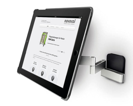 Eine Novocal iPad-Halterung Variante 1 für 7-12 Zoll Tablets, schwenkbar bis zu 180°, ist auf einer weißen Fläche montiert und hält ein Tablet, das die Novocal Website mit Produktinformationen und Navigation anzeigt.