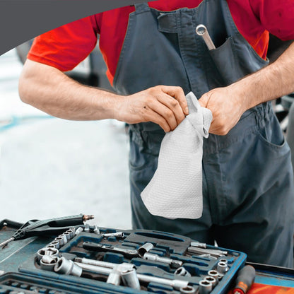 A person in red and gray uses the WypAll® X80 PowerClean cleaning cloths (BRAG™ Box, White, 1x160 Sheets) from Kimberly-Clark GmbH at a tool-filled workbench - ideal for demanding industrial cleaning.