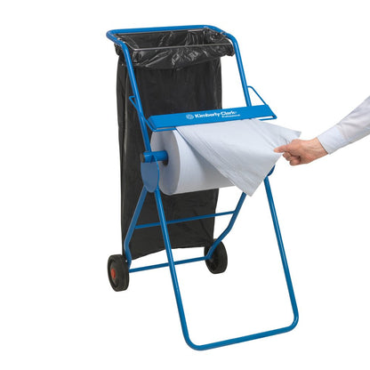 A blue paper towel dispenser with a black garbage bag is visible, while a hand pulls a sheet from a WypAll® X60 General Clean Large Roll (1 Roll x 500 Sheets, Blue) from Kimberly-Clark GmbH - ideal for professional cleaning tasks.