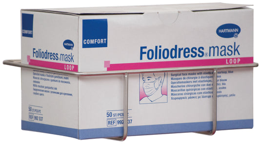 Eine Novocal Mundschutzboxhalterung aus Edelstahl zur Wandmontage (198 x 136 x 65 mm) hält eine Box "Foliodress mask LOOP" mit 50 OP-Masken, die Text und eine Zeichnung einer maskierten Person zeigt.