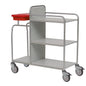 The durable Novocal station cart made of stainless steel with three shelves, four wheels, and a red plastic container on the top left is empty and depicted on a white background. All pipe connections are welded all around.