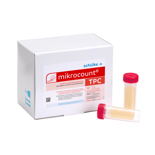 A white box labeled “Schülke & Mayr GmbH Mikrocount® TPC, Culture Medium | Pack (20 pieces)” with a logo and a product description next to two vials for microbial testing, one with a yellow cap and the other with a clear cap.