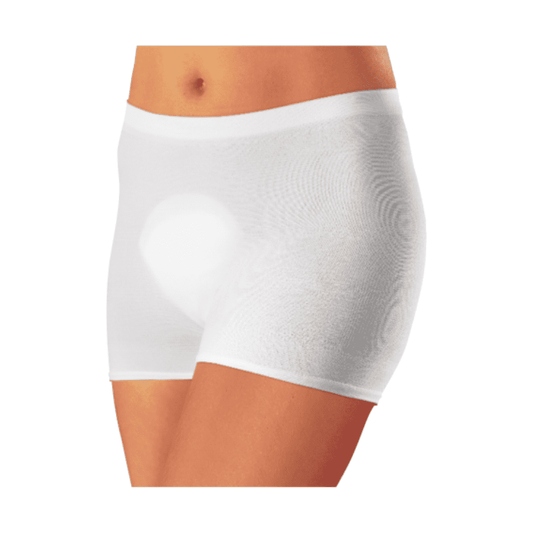 Eine Nahaufnahme einer Person, die weiße, figurbetonte Boxershorts „Seni Fix Comfort elastische Fixierhöschen“ von TZMO Deutschland GmbH trägt, mit Fokus auf den Bereich von der Taille bis zur Mitte des Oberschenkels vor einem weißen Hintergrund.