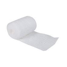 A partially unrolled roll of a white, elastic bandage with a textured pattern lies on a white surface. The Söhngen WS-elast. gauze bandage 8 cm x 4 m from W. Söhngen GmbH has high elasticity, making it light and ideal for medical and supportive use in any first aid facility.