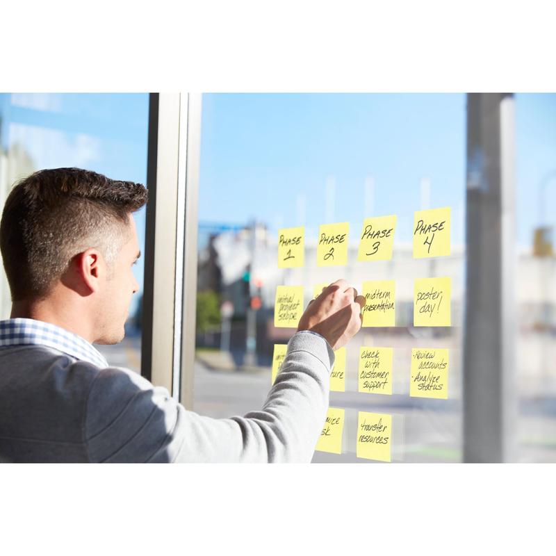 A man uses Post-it® Super Sticky Notes (76mm x 127mm, 90 sheets/block, 100% PEFC) from 3M Deutschland GmbH to organize project phases and tasks on a window and plan a workflow in daylight.