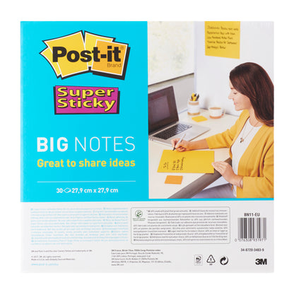 A woman in a yellow blazer writes at her desk on Post-it® Super Sticky Big Notes BN11-EU (279 x 279 mm, 30 sheets, yellow) from 3M Deutschland GmbH. The packaging indicates PEFC certification (SGSCH-PEFC-COC-110078).