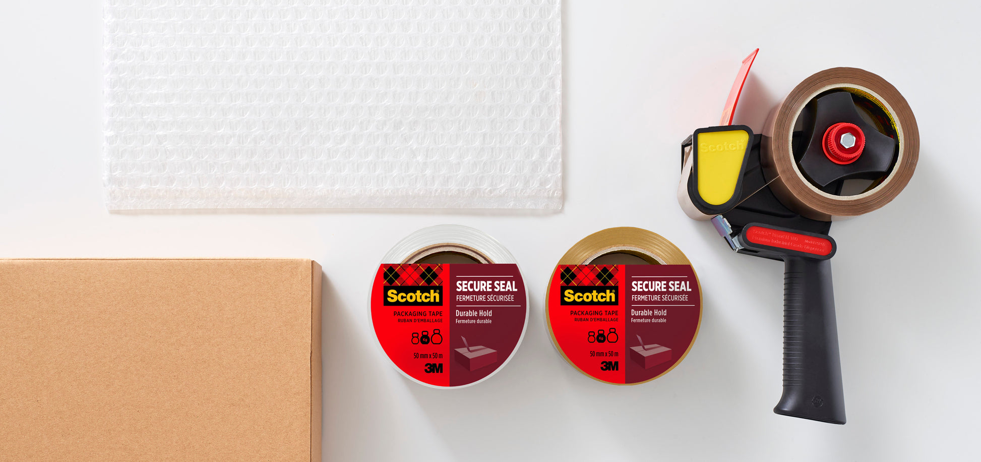Auf einer weißen Fläche liegen ein Abroller mit Pistolengriff und zwei Rollen Scotch® Verpackungsklebeband (braun, 50mm x 66m) von 3M Deutschland GmbH, zusammen als Set mit Dispenser in einer Packung.