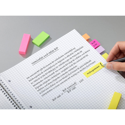 Eine Hand schreibt auf einem karierten Notizbuch mit hervorgehobenen deutschen Notizen über "nominales und reales BIP". In der Nähe befinden sich Post-it® Page Marker, Energetic Collection (25x76 mm, 3er-Pack) der 3M Deutschland GmbH. Bunte Klebelaschen ordnen die Seite.